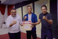 Lawyer PT NHM Iksan Maujud hadiah kepada peserta upacara. 